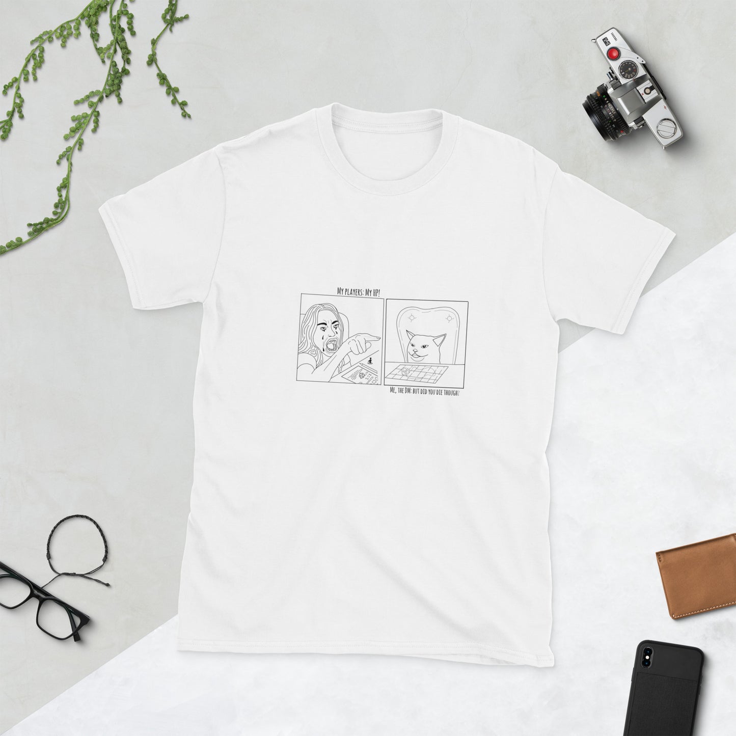 White t-shirt with black graphic design on a light gray surface with accessories around