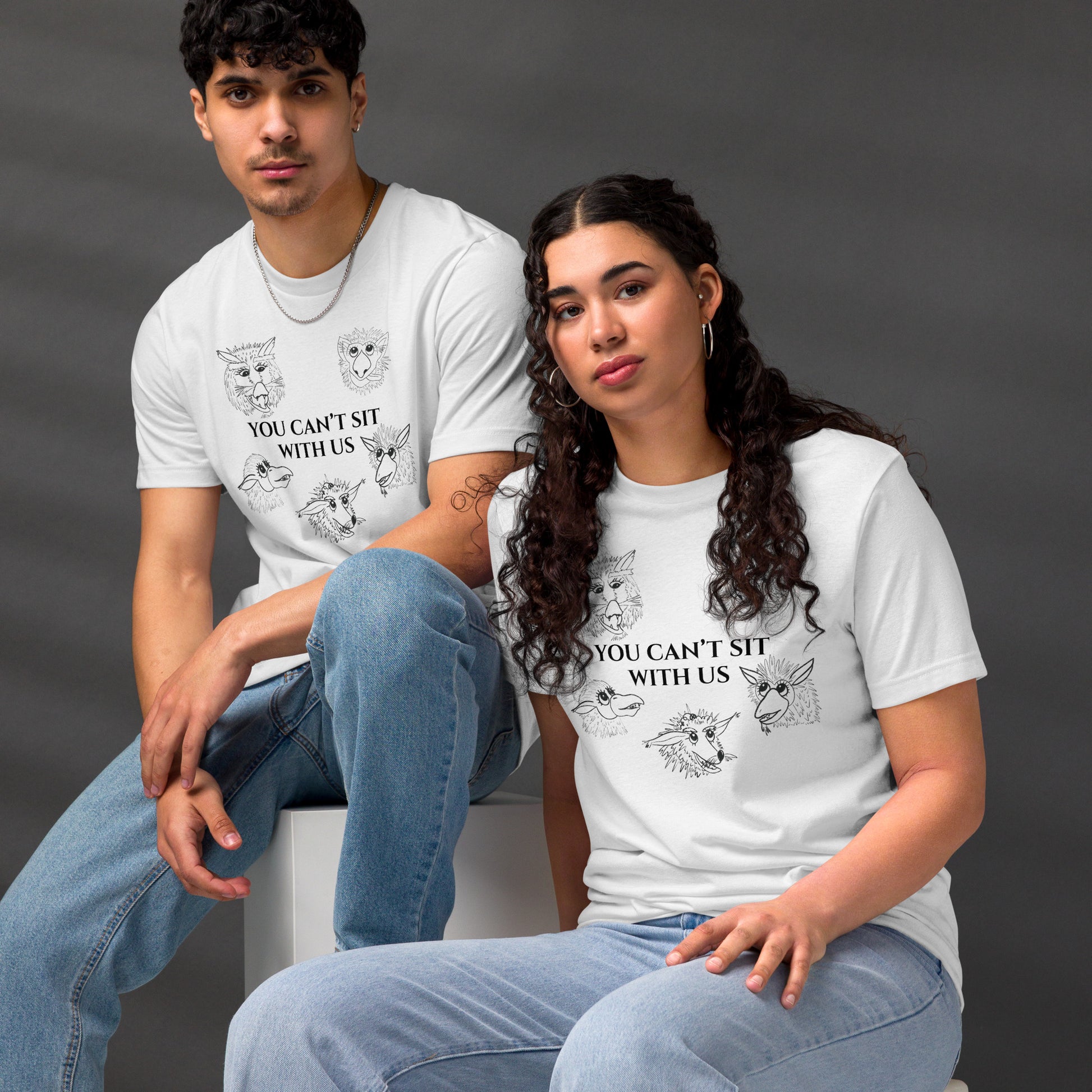 Two people wearing white t-shirts with printed designs and text against a dark background